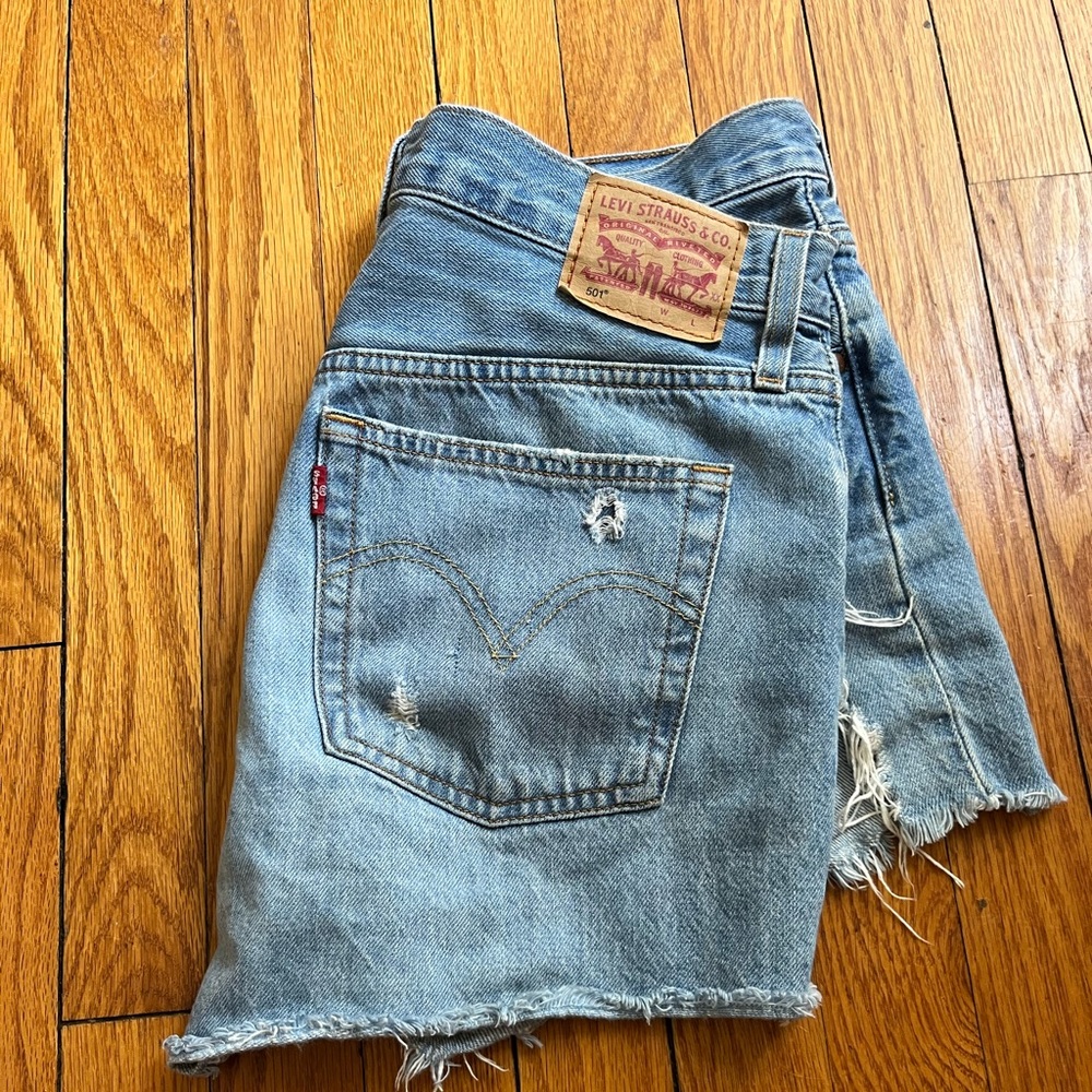 Levi 501 Jean shorts. light wash, distressing on front and back.